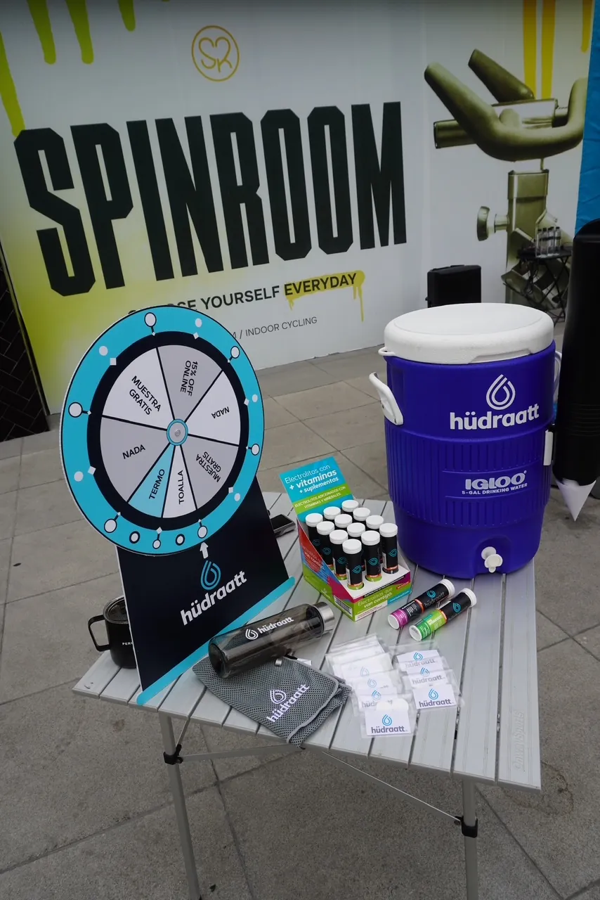 Mesa con tubos de Hudraatt, termo de agua y ruleta de premios en Spinroom